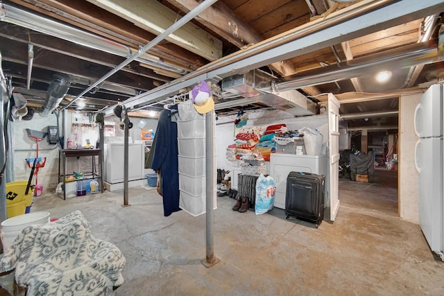 basement featuring white refrigerator and washing machine and clothes dryer