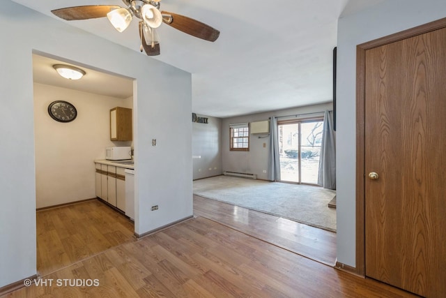 kitchen with a baseboard radiator, ceiling fan, and light hardwood / wood-style floors