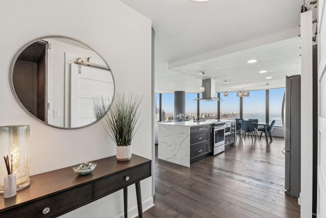 hallway featuring dark hardwood / wood-style flooring, a water view, and expansive windows