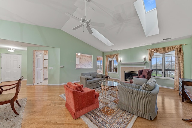 living room with light hardwood / wood-style floors, vaulted ceiling, and ceiling fan