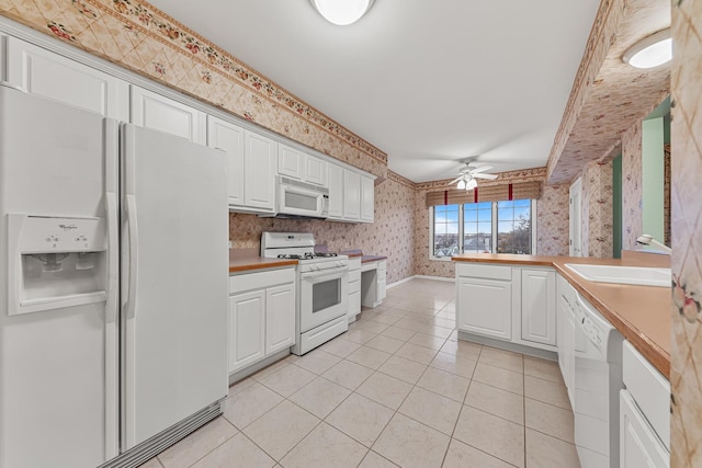 kitchen with white cabinetry, light tile patterned floors, white appliances, and ceiling fan