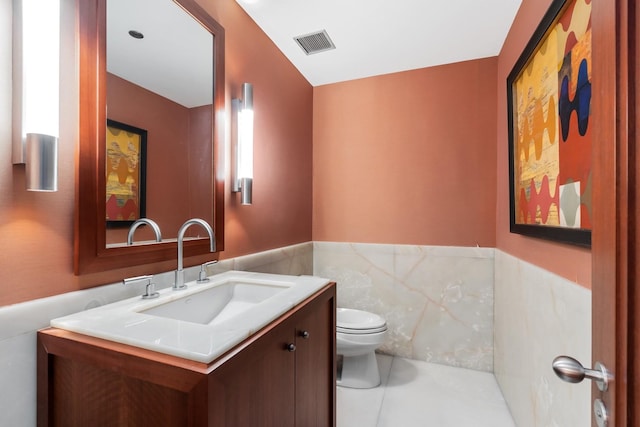 bathroom with tile patterned flooring, vanity, and toilet