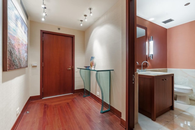 hall featuring wood-type flooring and sink