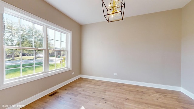 unfurnished dining area with light hardwood / wood-style floors and a chandelier