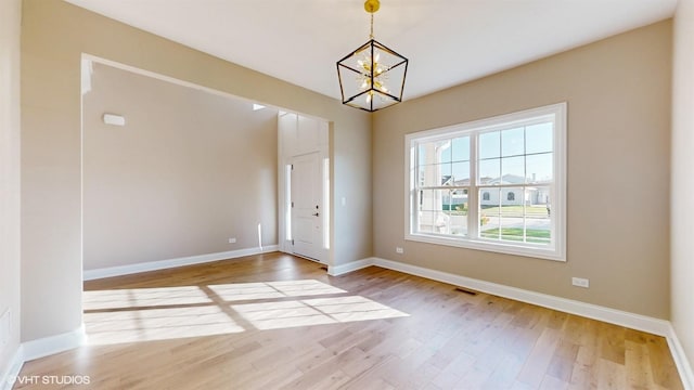 foyer with light hardwood / wood-style flooring and a chandelier