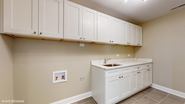 laundry room featuring tile patterned floors, cabinets, sink, and washer hookup