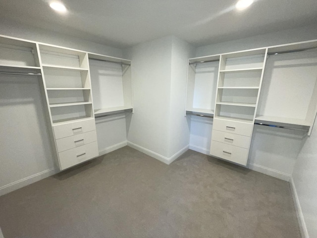 walk in closet featuring dark carpet