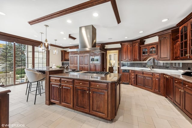 kitchen with stainless steel appliances, island exhaust hood, decorative light fixtures, a kitchen island with sink, and ornamental molding