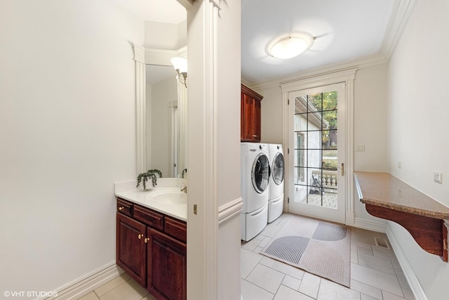 washroom with cabinets, light tile patterned floors, washer and clothes dryer, and crown molding