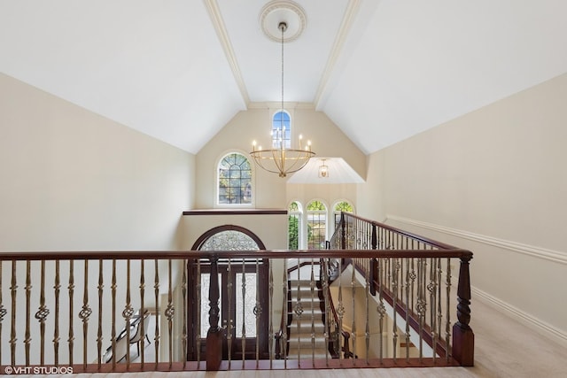 staircase featuring a chandelier, carpet floors, and vaulted ceiling