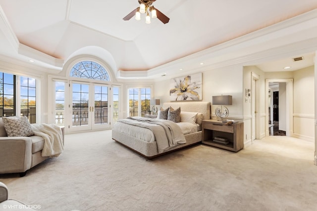 bedroom featuring ceiling fan, light carpet, access to outside, and a tray ceiling