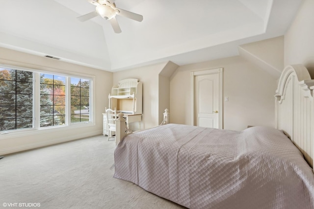 carpeted bedroom with a tray ceiling, ceiling fan, and vaulted ceiling