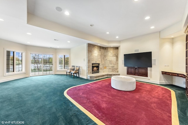 living room featuring dark colored carpet and a fireplace