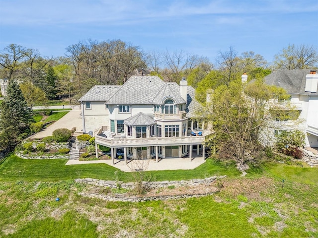 back of house featuring a lawn, a patio area, and a deck