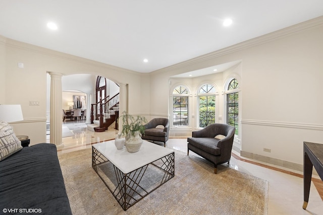 living room with crown molding and decorative columns