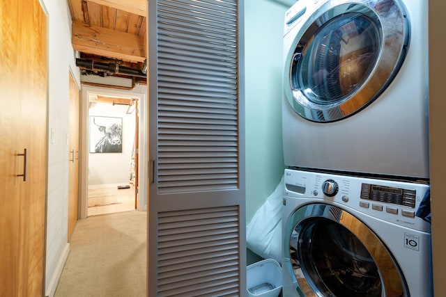 clothes washing area with stacked washer and dryer and light colored carpet