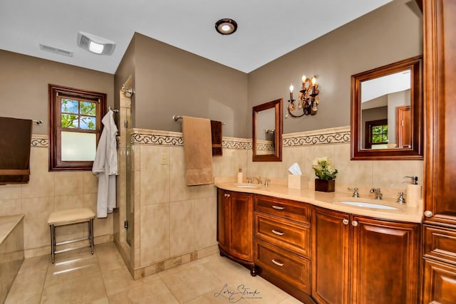 bathroom with tile patterned flooring, vanity, a shower, and tile walls