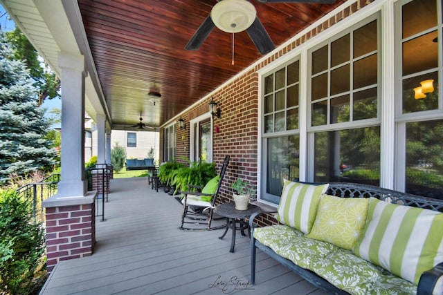 wooden terrace with a porch and ceiling fan