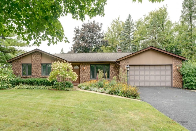 ranch-style house featuring a front yard and a garage