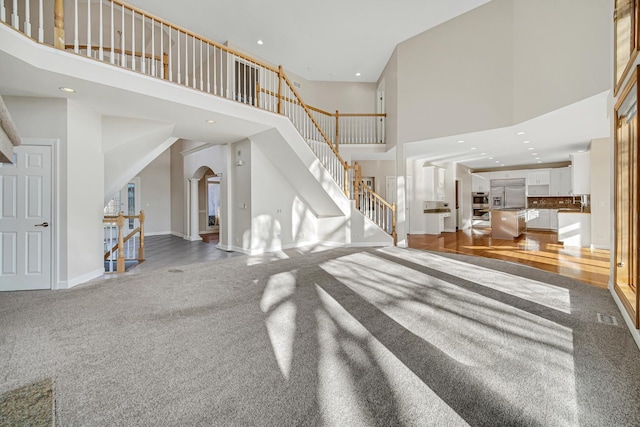 interior space featuring carpet flooring and a towering ceiling