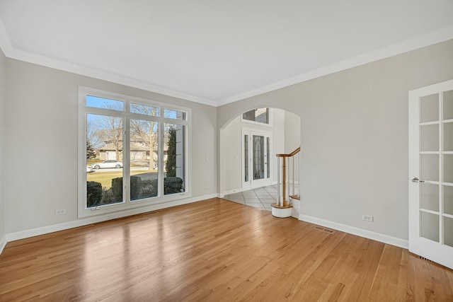 unfurnished living room featuring ornamental molding and light wood-type flooring