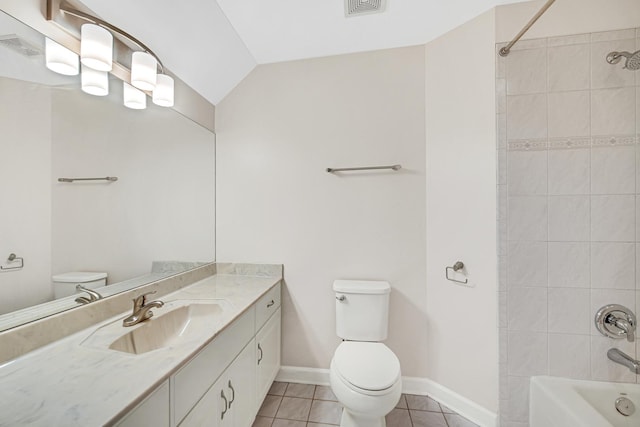 full bathroom featuring tiled shower / bath combo, tile patterned flooring, lofted ceiling, toilet, and vanity