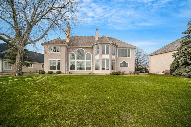 rear view of property featuring a lawn