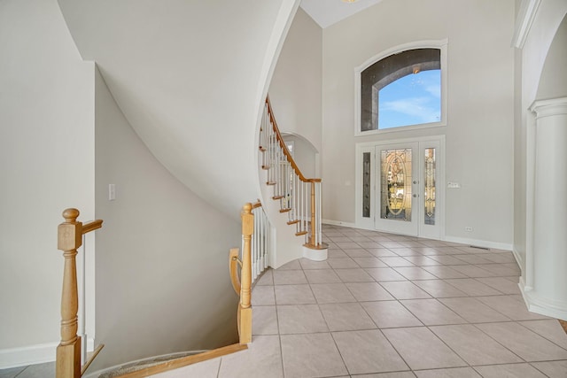 tiled foyer with a towering ceiling