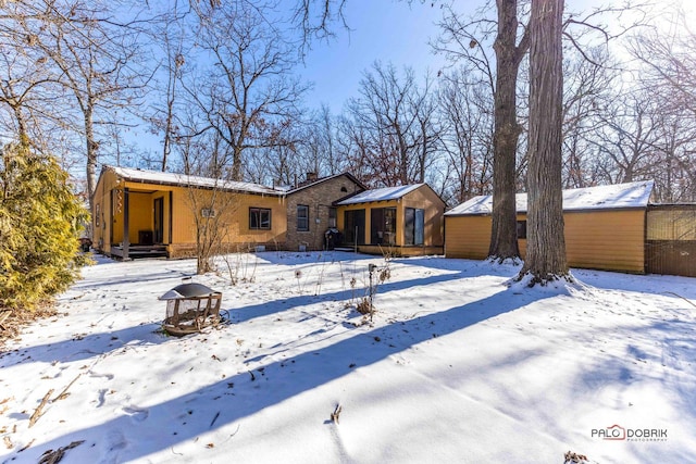 snow covered property featuring a sunroom