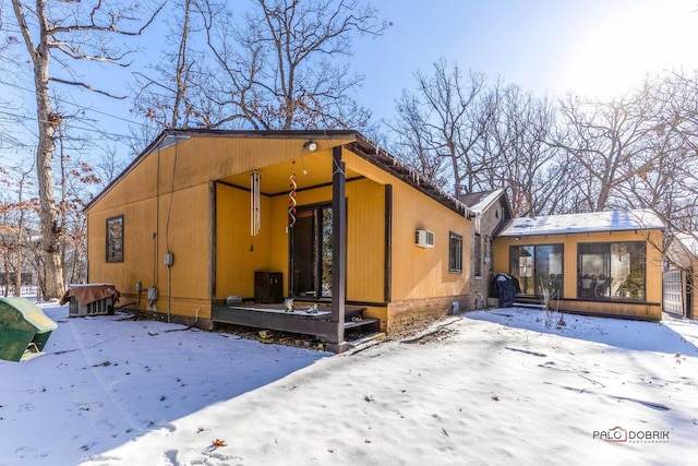 view of snowy exterior featuring a sunroom