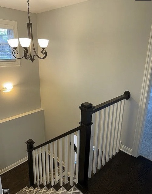 staircase featuring a chandelier and wood-type flooring