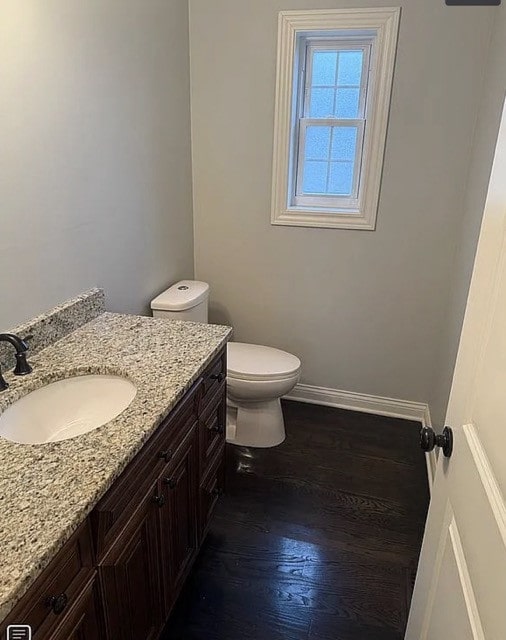 bathroom with hardwood / wood-style flooring, vanity, and toilet