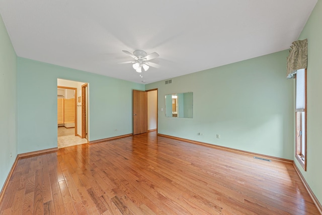 unfurnished bedroom featuring connected bathroom, ceiling fan, and light hardwood / wood-style floors