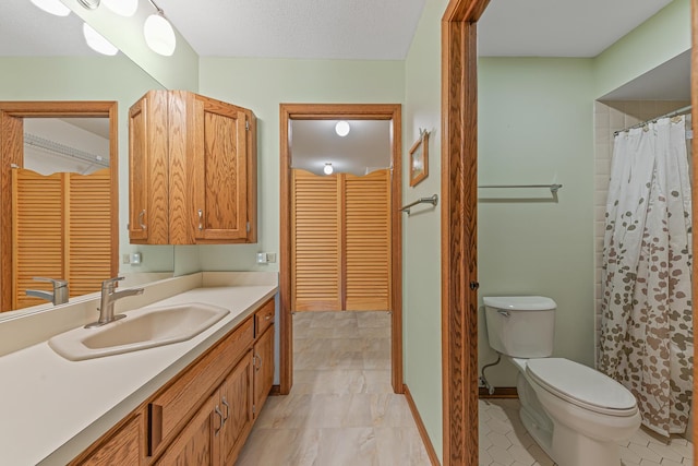 bathroom featuring vanity, a textured ceiling, and toilet