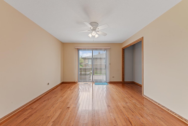 empty room featuring a textured ceiling, light hardwood / wood-style flooring, and ceiling fan