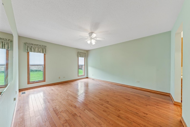 unfurnished room featuring a textured ceiling, light hardwood / wood-style flooring, and ceiling fan