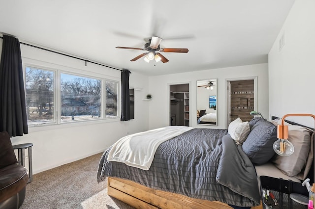 carpeted bedroom featuring a spacious closet and ceiling fan