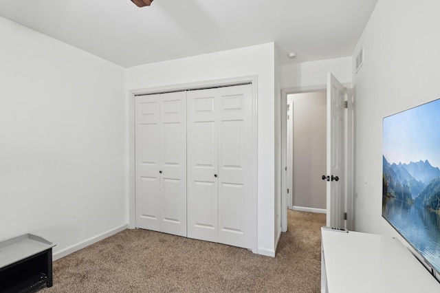 unfurnished bedroom featuring light colored carpet and a closet