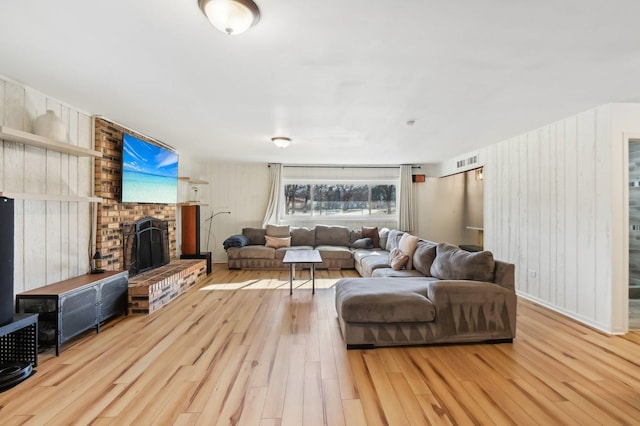 living room with a fireplace and light hardwood / wood-style flooring