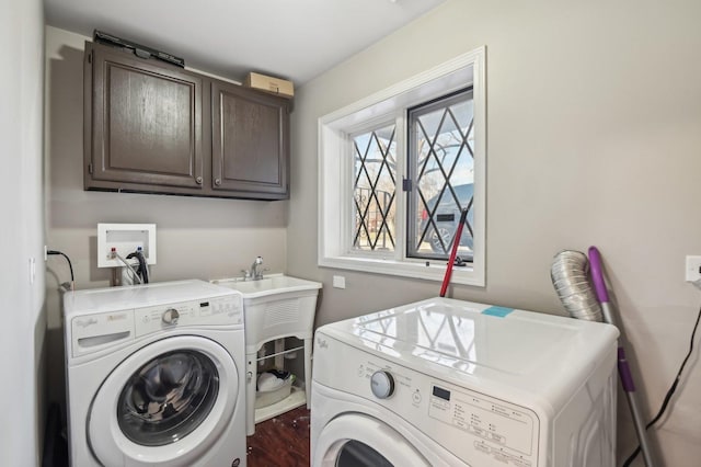 clothes washing area featuring cabinets, dark hardwood / wood-style floors, and washing machine and clothes dryer