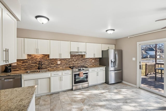 kitchen with sink, appliances with stainless steel finishes, backsplash, light stone counters, and white cabinets