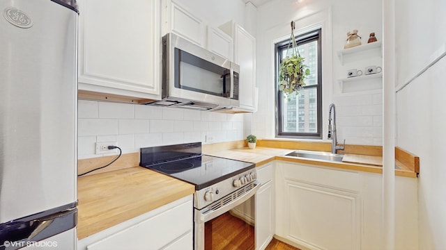 kitchen featuring sink, white cabinets, backsplash, and appliances with stainless steel finishes