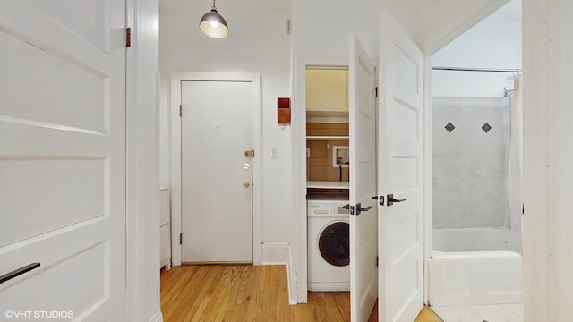 washroom with washer / clothes dryer and light wood-type flooring