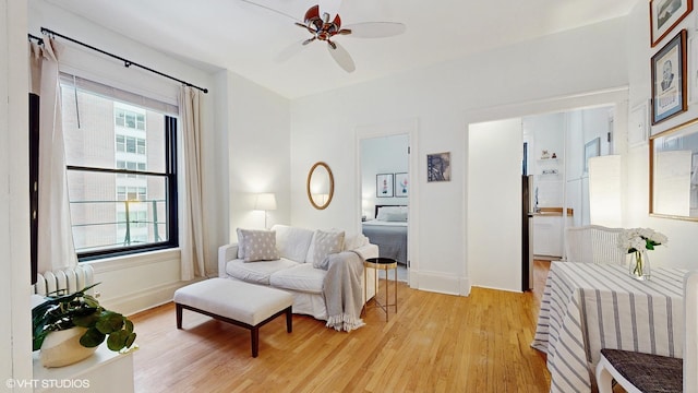 sitting room with light wood-type flooring and ceiling fan