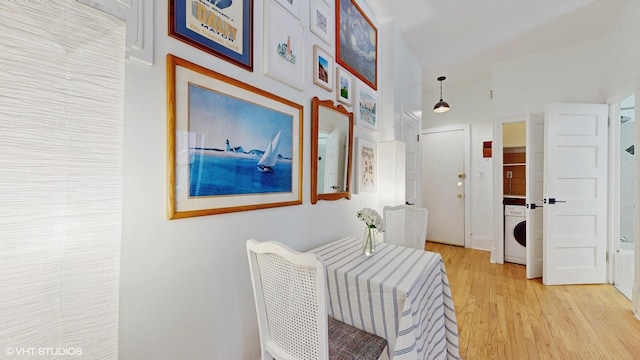 corridor with washer / clothes dryer and light hardwood / wood-style flooring