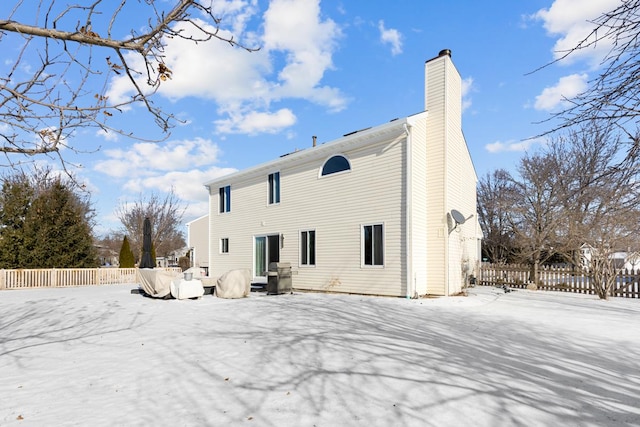 view of snow covered rear of property