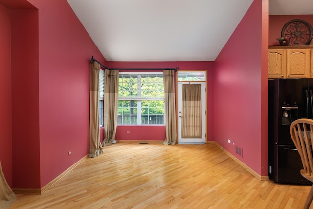 interior space featuring light wood-type flooring and lofted ceiling