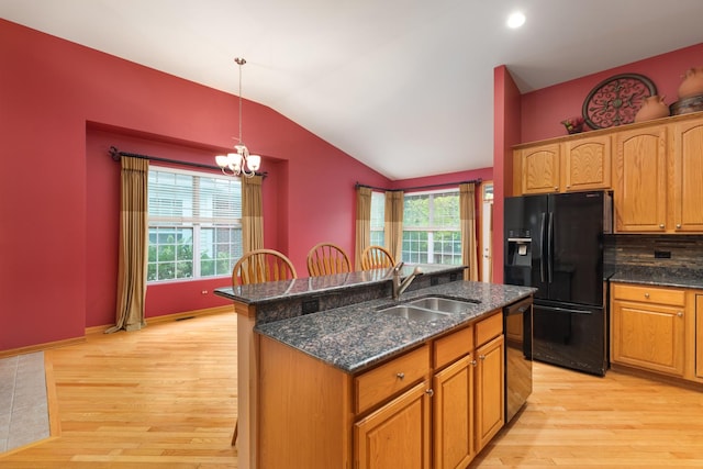 kitchen with sink, black appliances, a chandelier, light hardwood / wood-style floors, and hanging light fixtures