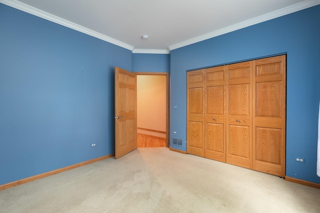 unfurnished bedroom featuring ornamental molding, light carpet, and a closet