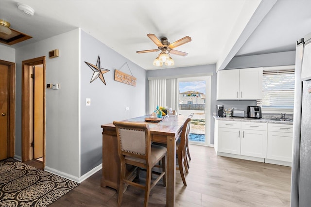 dining room with a healthy amount of sunlight, sink, ceiling fan, and light hardwood / wood-style flooring